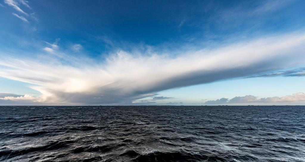 a cloudy sky over a large body of water at Hof Steinhütten in Westerhever