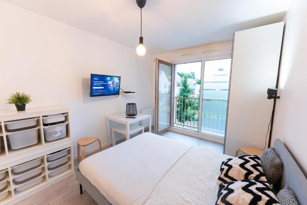 a bedroom with a bed and a large window at Studio à Disneyland Paris in Coupvray