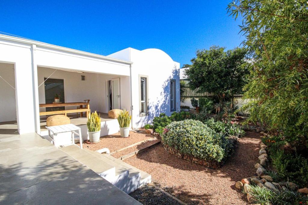 a white house with a patio with plants at Calm Oasis in the heart of the Karoo in Prince Albert