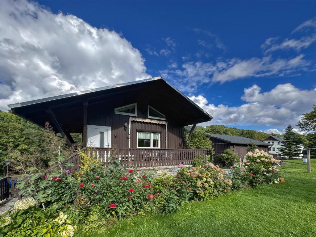 a small house with a balcony and flowers at Neubert in Arnoldshammer