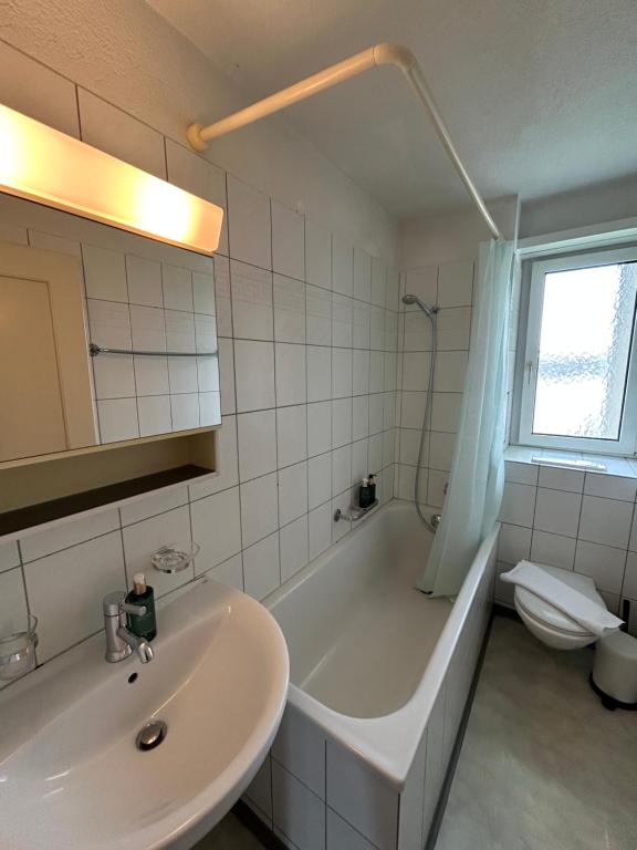 een badkamer met een wastafel, een bad en een toilet bij Comfort escape on Schwandenwiesen in Zürich