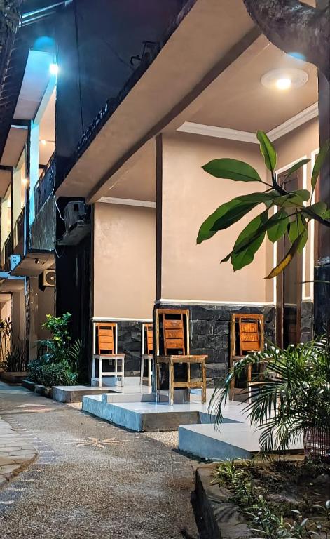 a group of chairs sitting outside of a building at Ayu Homestay in Kuta Lombok