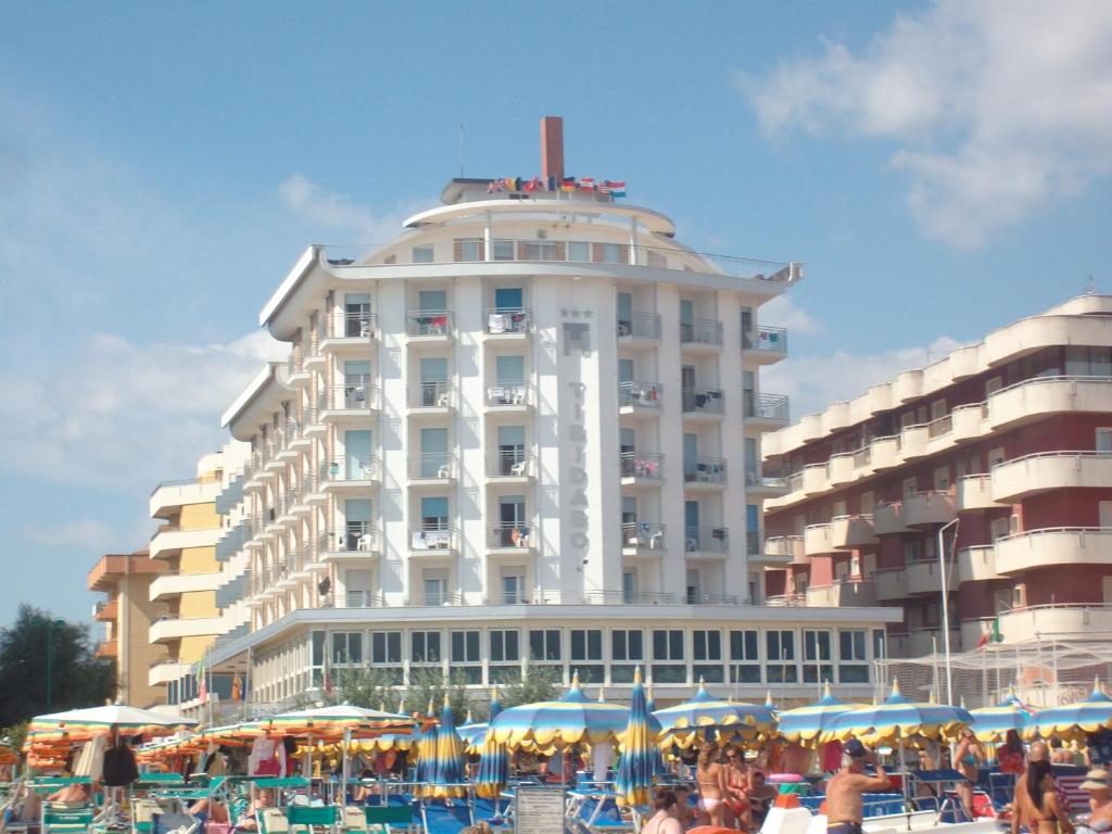 a large white building with umbrellas in front of it at Hotel Tibidabo in Bellaria-Igea Marina