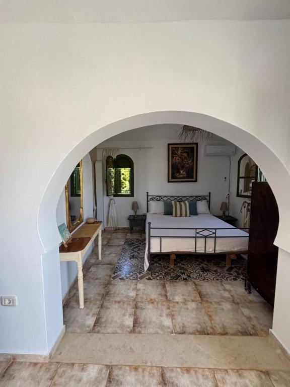 una camera da letto con un letto e un arco di Djerba houch a El Mây