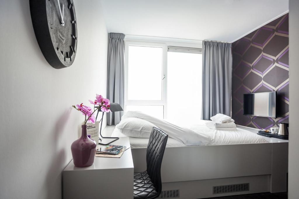 um quarto com uma cama e uma secretária com um vaso de flores em Stravinsky Slapen em Hengelo