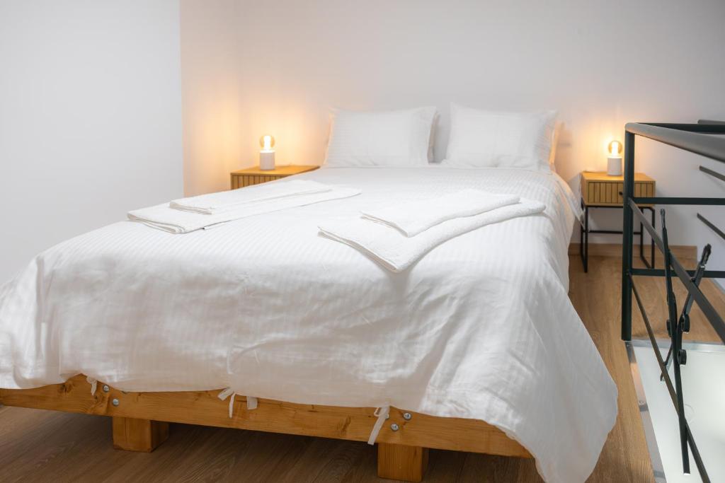 ein großes weißes Bett mit weißer Bettwäsche und Kissen in der Unterkunft Shortie loft in Ioannina