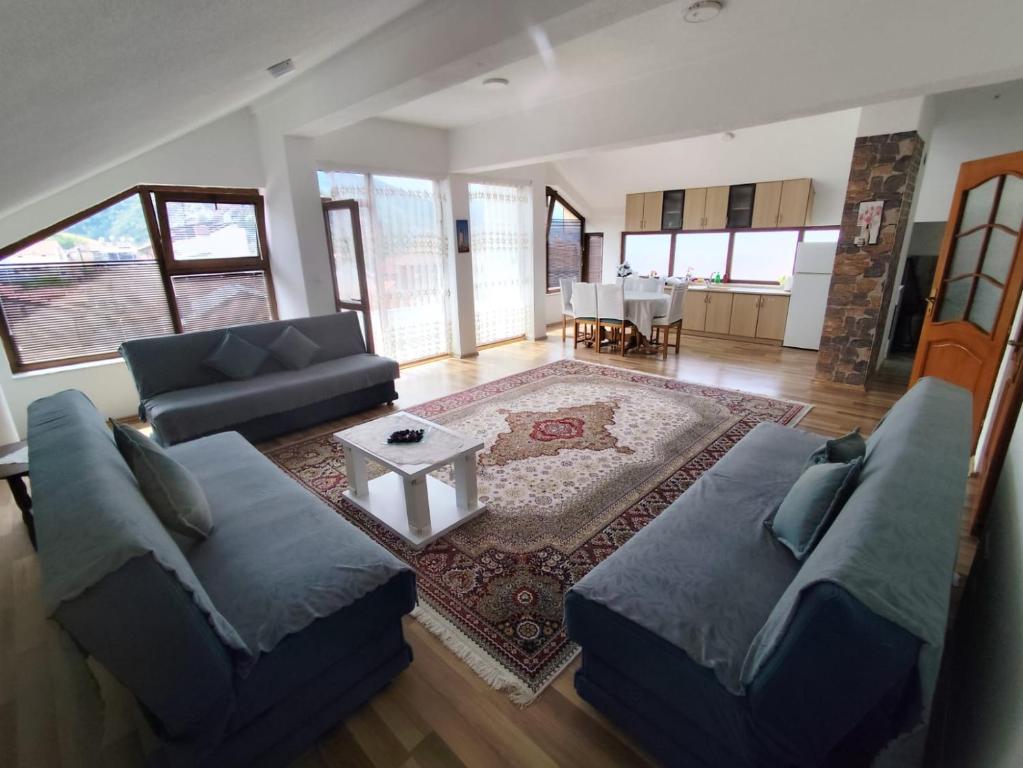 a living room with a couch and a table at White Apartment in Prizren