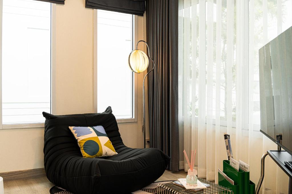 a black bean bag chair in a room with a window at anhaus chiangrai in Chiang Rai