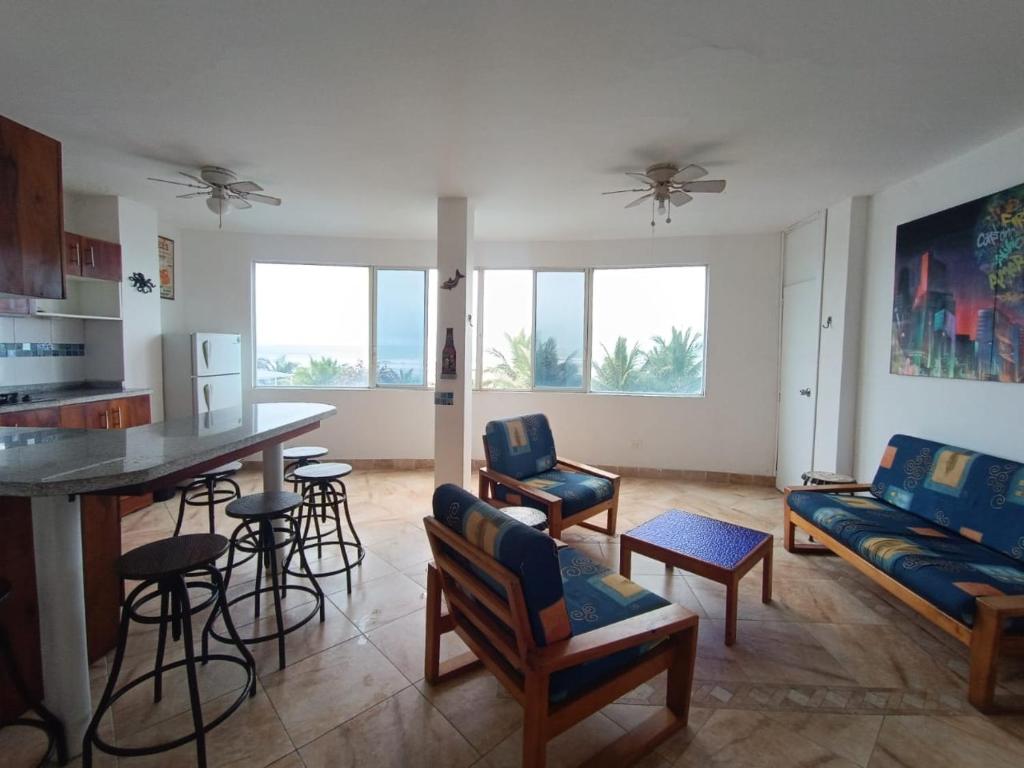 a living room with a couch and a table and chairs at Apartamento con vista a la playa frente al mar in El Recreo