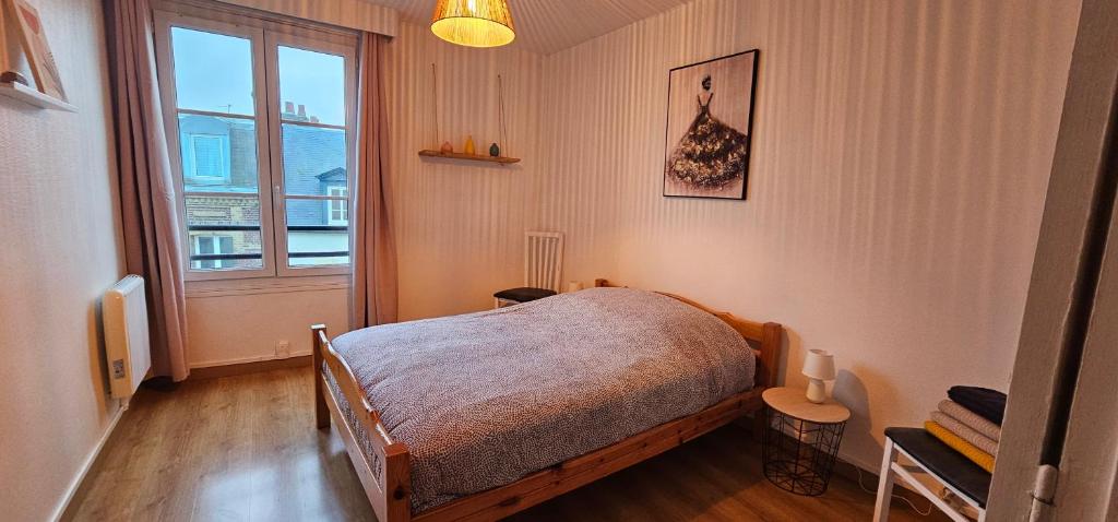 a small bedroom with a bed and a window at Au coeur de Dieppe, au puits salé BY HOLIDIEPPE in Dieppe