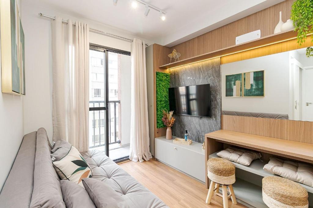a living room with a couch and a tv at Apartamento Moderno e Completo em Curitiba in Curitiba