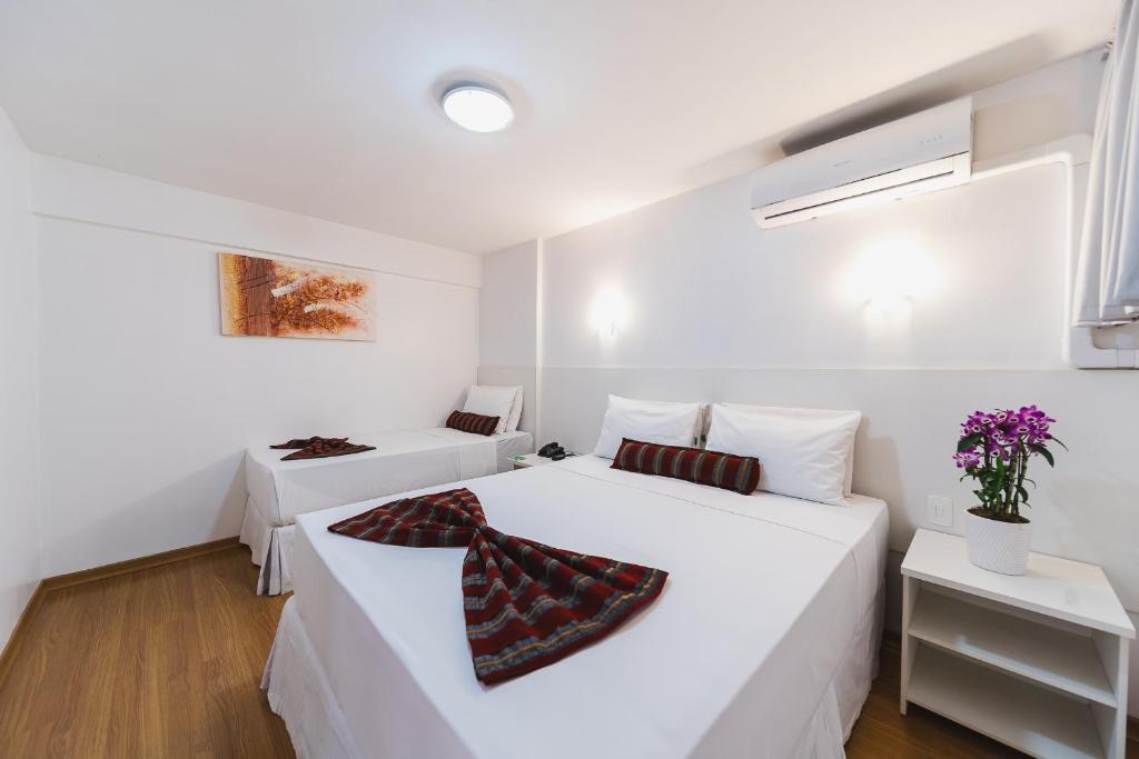 two beds in a room with white walls at Hotel Nacional Inn Curitiba Estação Shopping in Curitiba