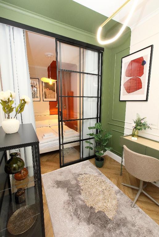 a living room with green walls and a glass door at Prestiżowy Apartament Rosette Residence 2 z tarasem AC Progres in Toruń