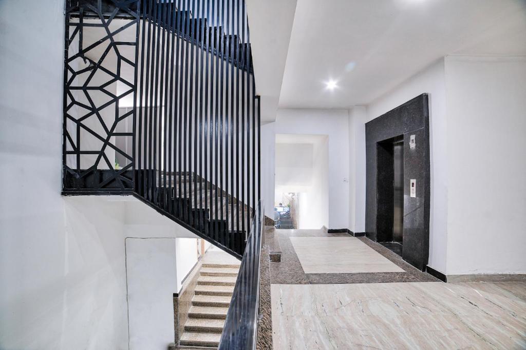 un pasillo con una escalera con barandillas negras en Hotel O Crown Residency, en Faridabad