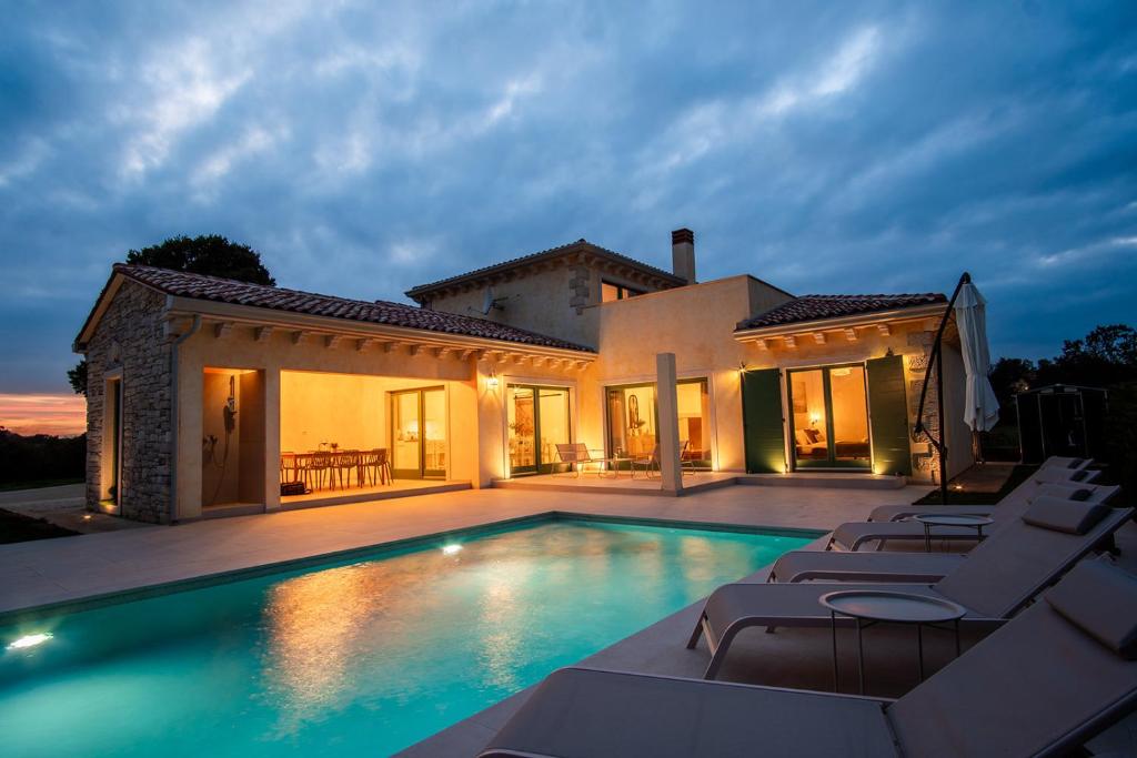a villa with a swimming pool in front of a house at Villa Kaia in Kringa