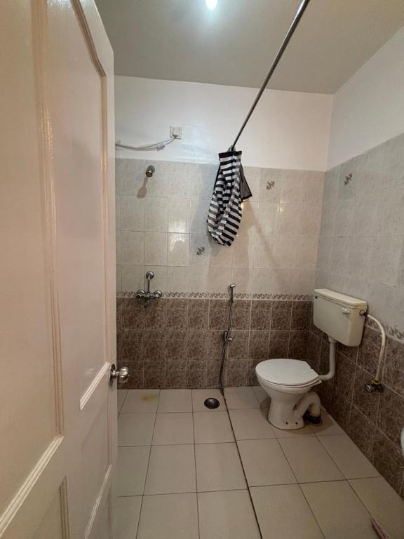 a small bathroom with a toilet and a shower at Sea Breeze Bay in Calangute