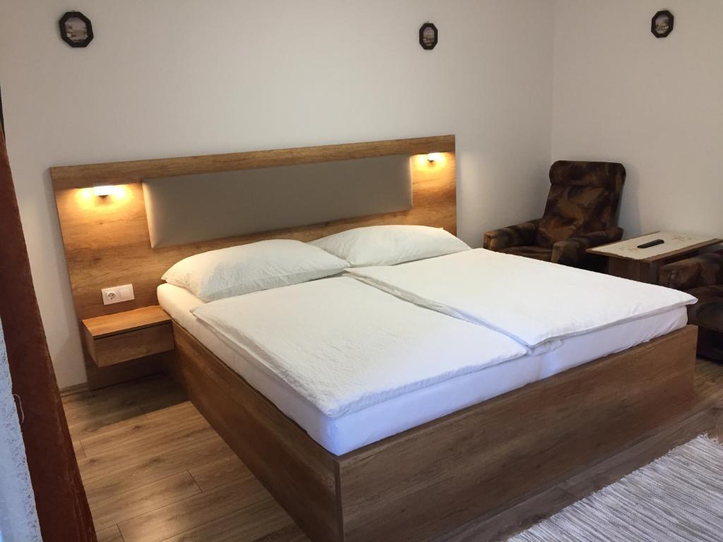 a bedroom with a bed and a chair in it at Bartók Apartman in Harkány