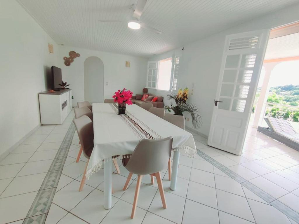 un salon blanc avec une table et des chaises dans l'établissement Exceptional villa KODEÏA - private spa & panoramic view, à Sainte-Marie