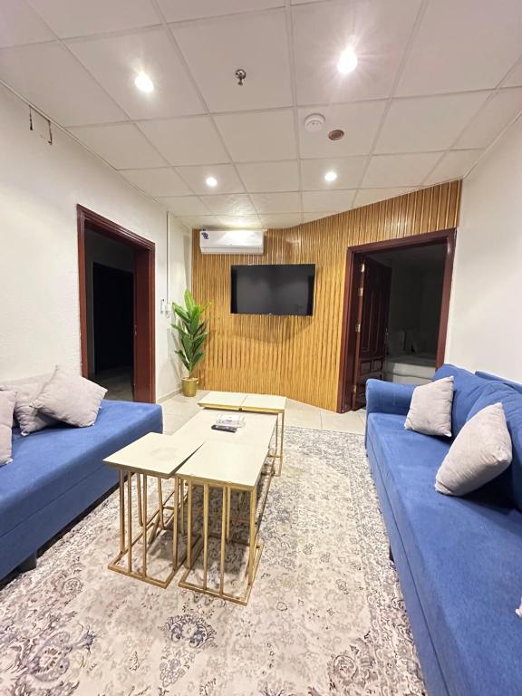 a living room with a blue couch and a table at شقق نرمادا المفروشه402 in Al Madinah