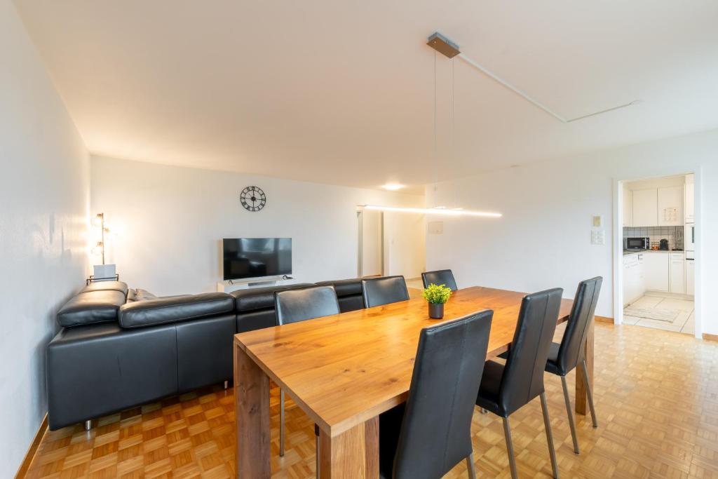 a dining room with a table and a couch at Swiss Suites Oberrohrdorf in Rohrdorf