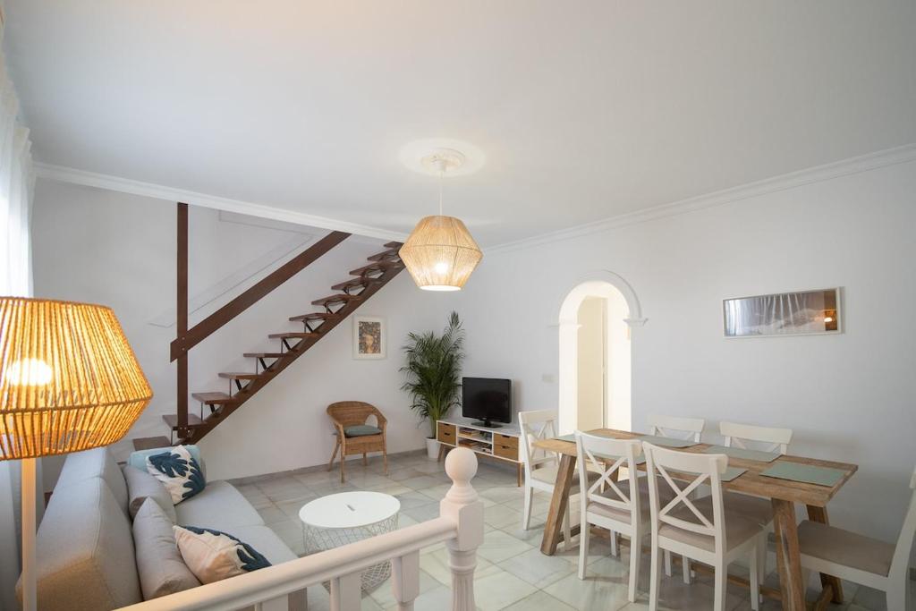 a living room with a table and a dining room at Casa Salmedina in Sanlúcar de Barrameda