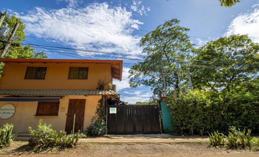 a yellow house with a gate and a fence at Casa Playa Avellanas in Santa Cruz