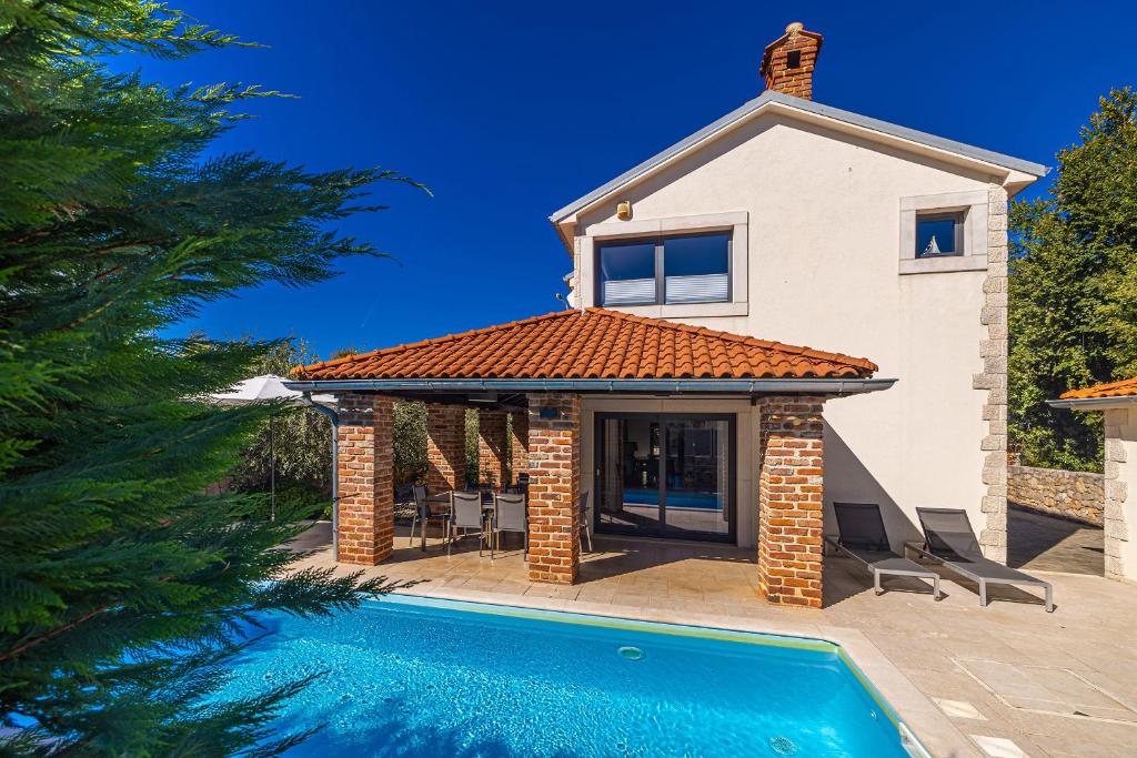 a house with a swimming pool in front of a house at Villa Kvarner in Krk