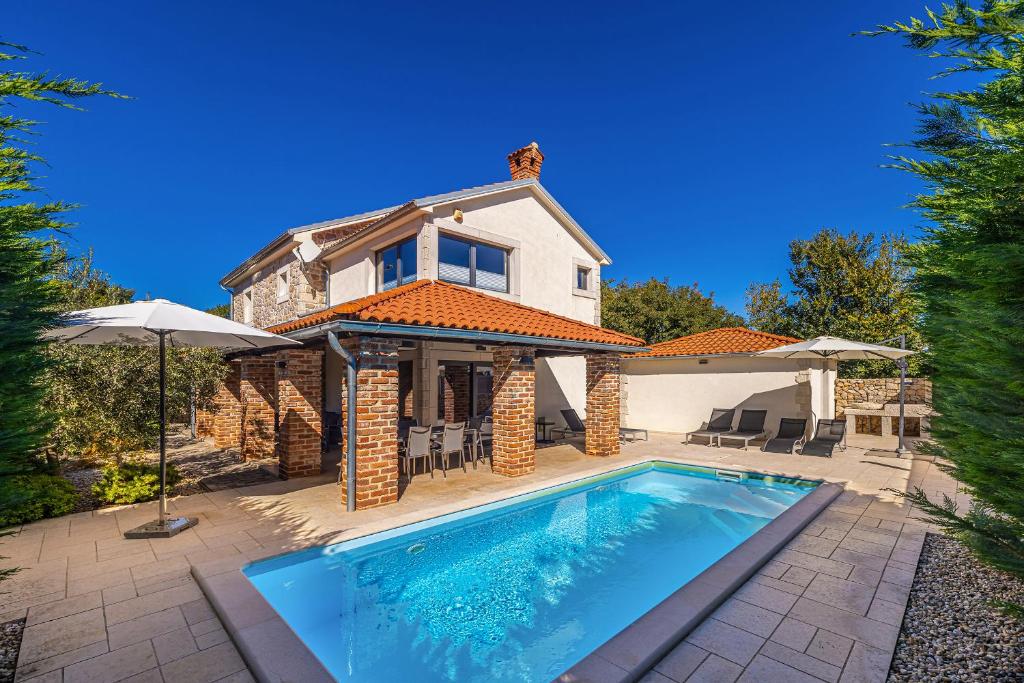 a house with a swimming pool in front of a house at Villa Kvarner in Krk