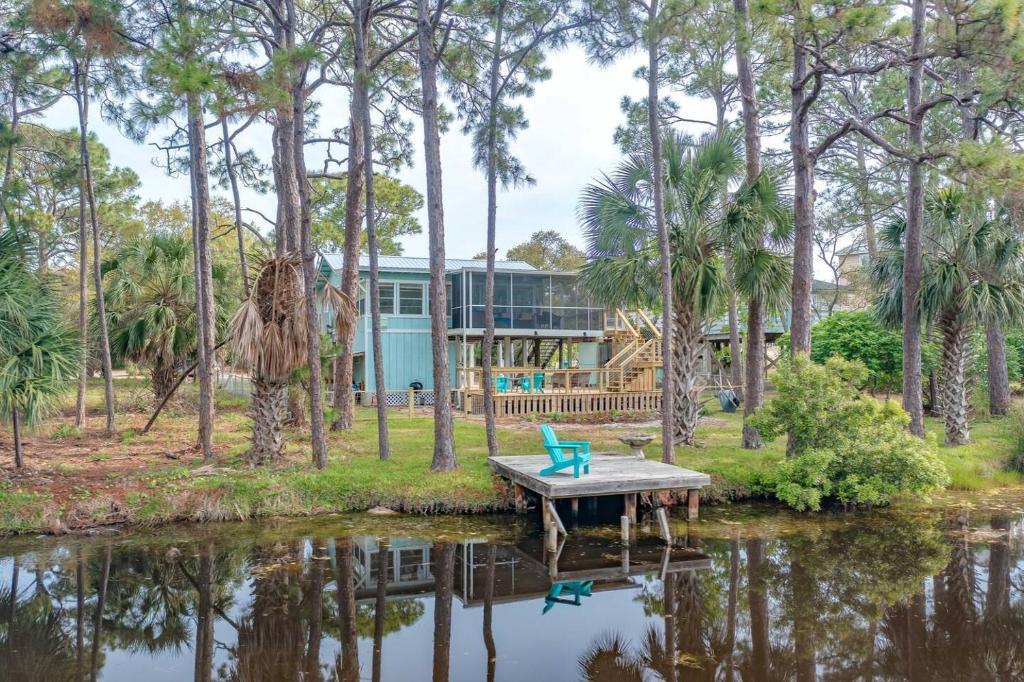 a house on the water with a dock and a bench at For The Birds- On The Water in Sun N Sand Beaches