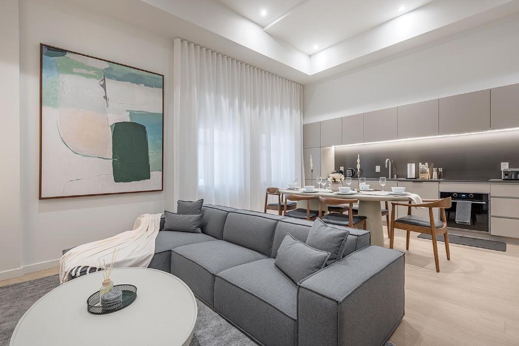 モントリオールにあるLuxury 4BR 3BA Penthouse with Private Terraceのリビングルーム(グレーのソファ付)、キッチンが備わります。