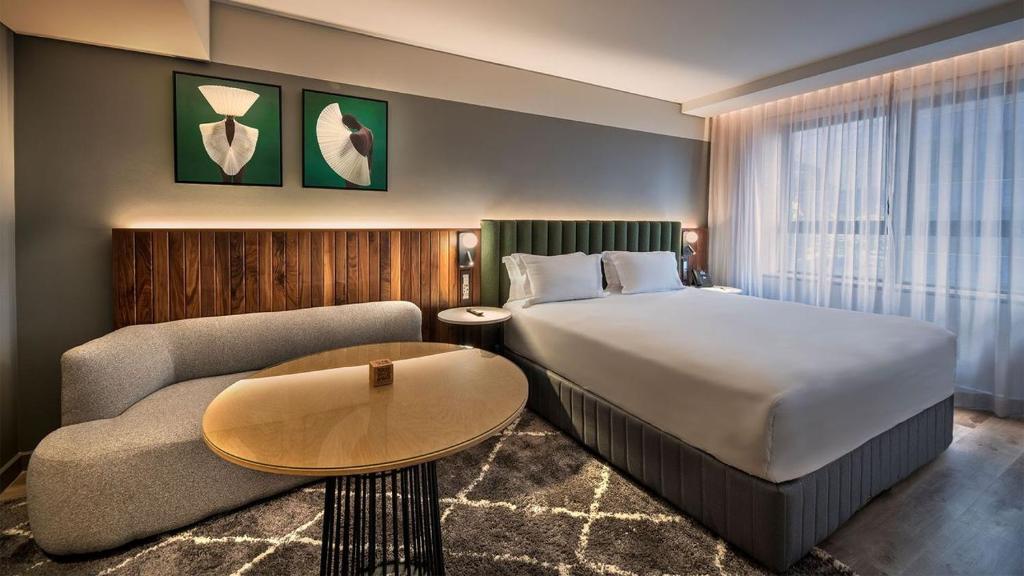 a hotel room with a bed and a couch at The Rockefeller Hotel Cape Town in Cape Town