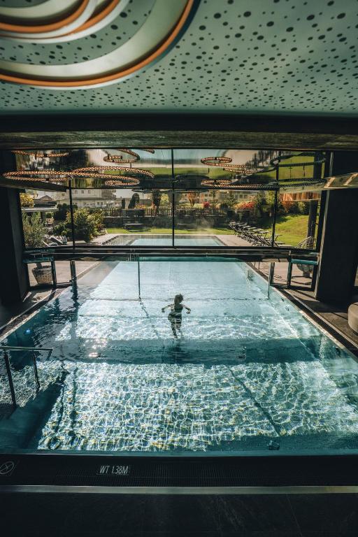 a person in a swimming pool in a building at Hotel Wagnerhof in Pertisau