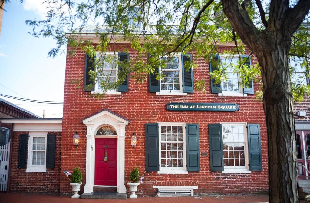 um edifício de tijolos vermelhos com uma porta vermelha em The Inn at Lincoln Square em Gettysburg