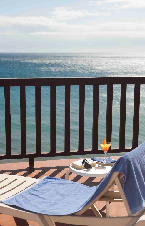 a table and chair on a balcony overlooking the ocean at Doña Pakyta in San José