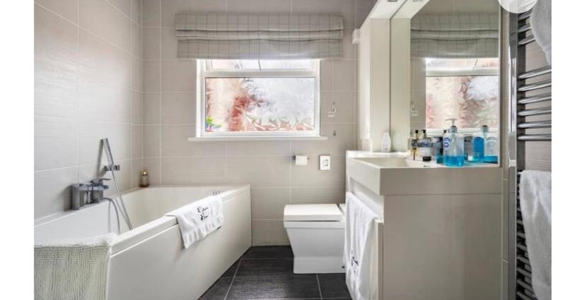 a white bathroom with a tub and a sink at Cullentra House in Cushendall
