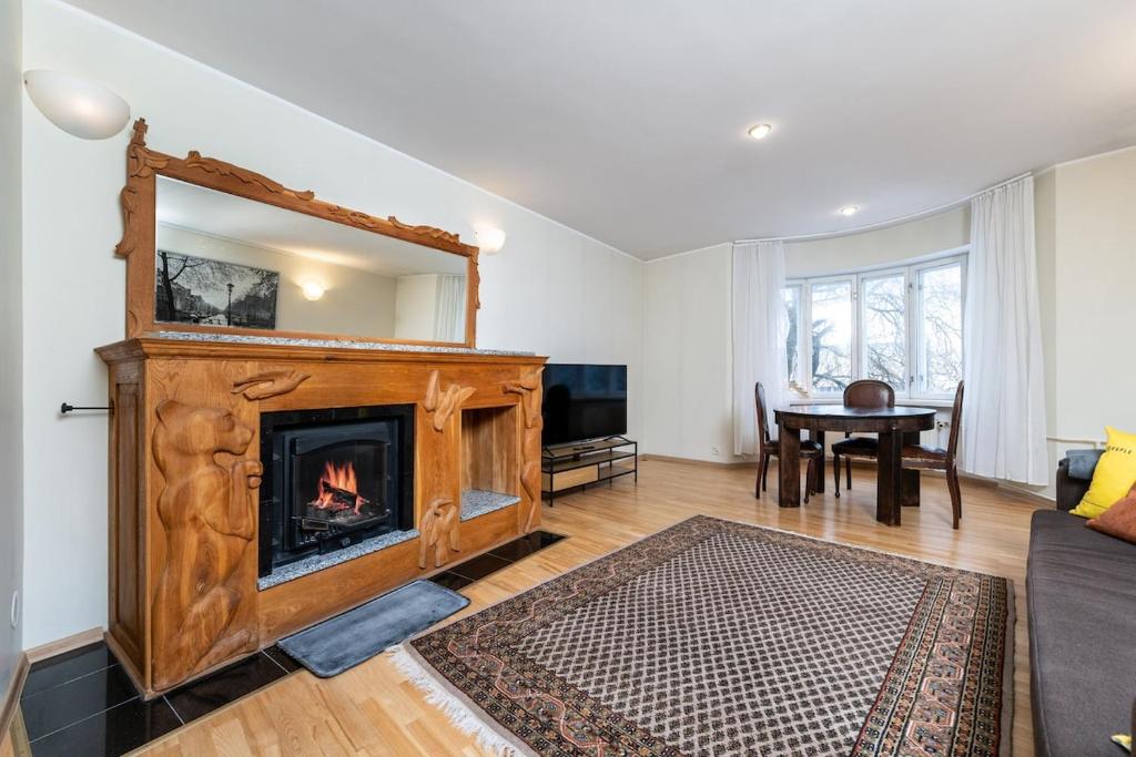 Una sala de estar con chimenea y una mesa. en 5 min from Port - free private parking - 1BR, en Tallin