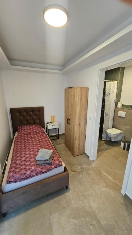 ヘルフォルトにあるHotel Akropolisのベッドのある寝室とトイレのある浴室