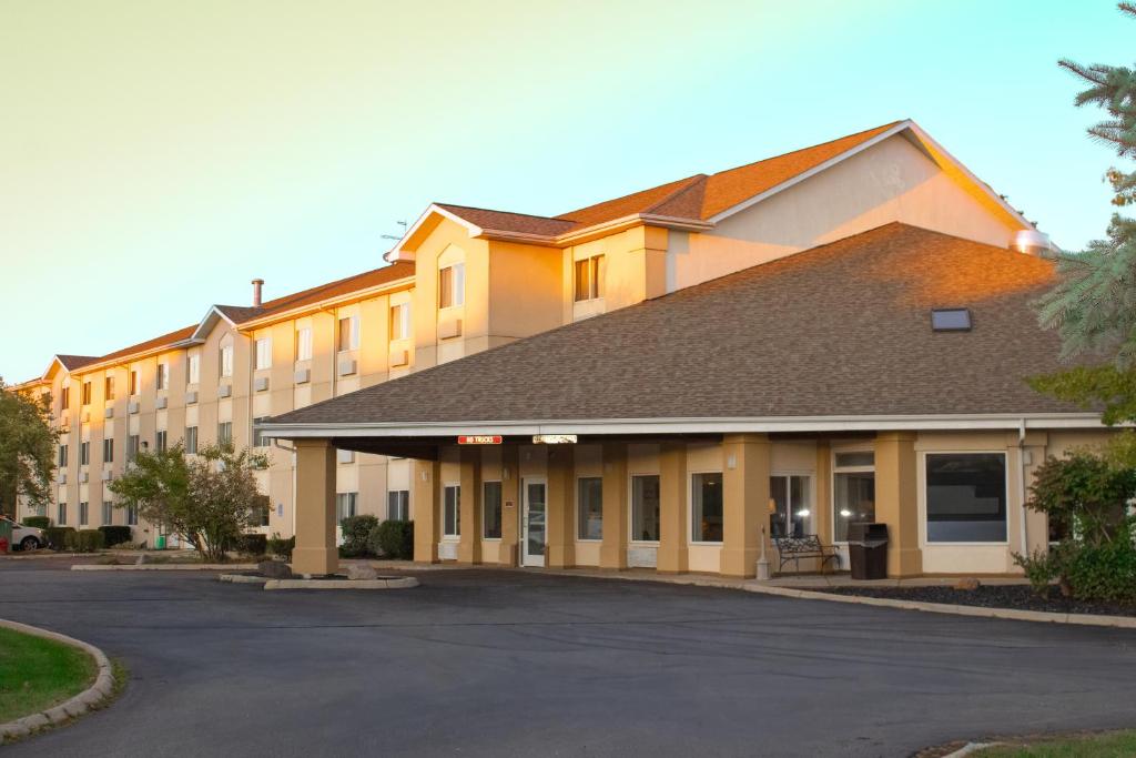 a large building with a parking lot in front of it at Baymont by Wyndham Howell/Brighton in Howell