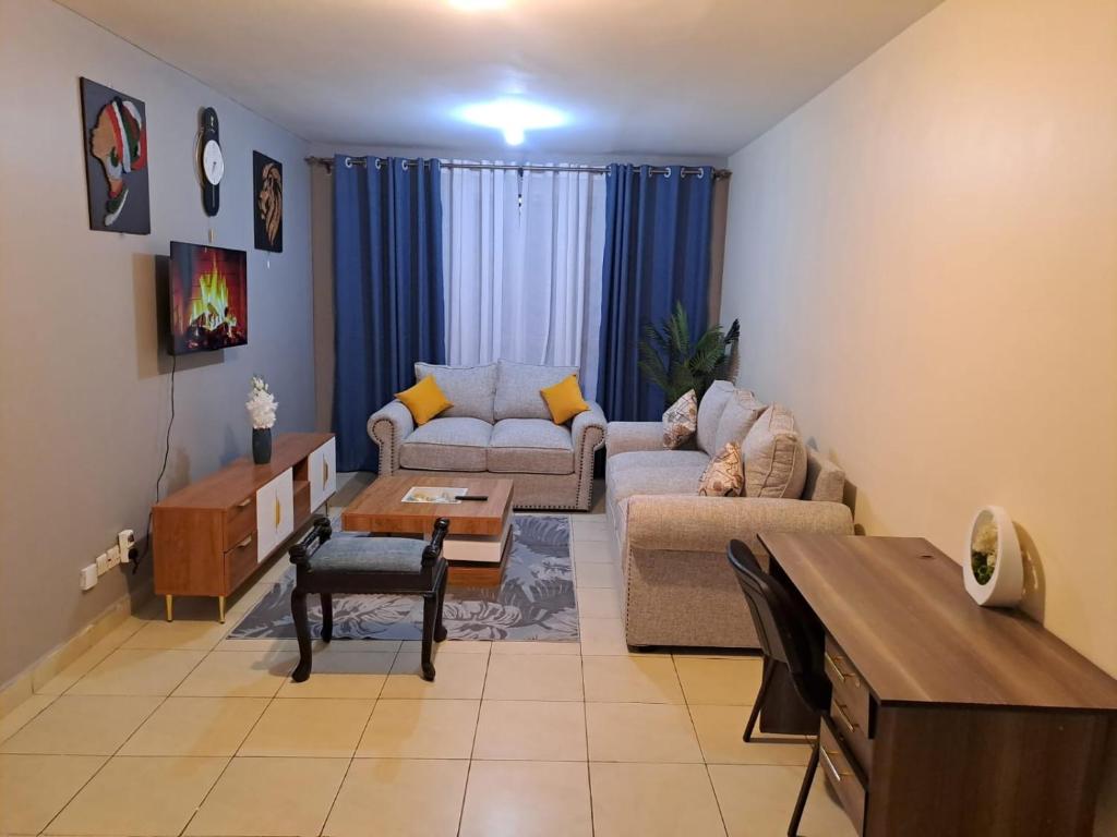 a living room with a couch and a table at Tulia homes in Kanga