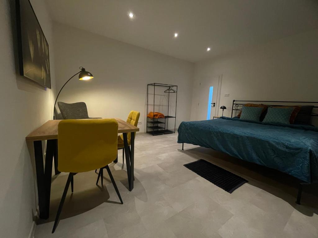 a bedroom with a bed and a table and yellow chairs at Monstera III - industrial in Kolín