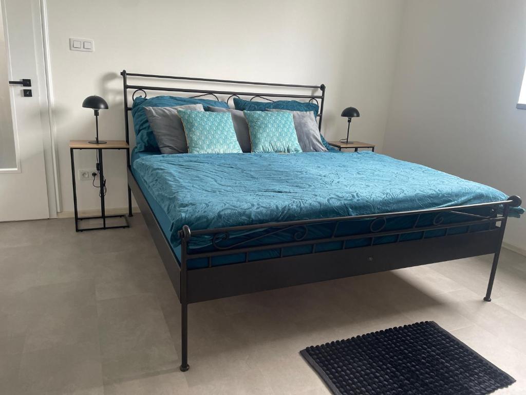 a bedroom with a bed with blue sheets and pillows at Monstera III - industrial in Kolín