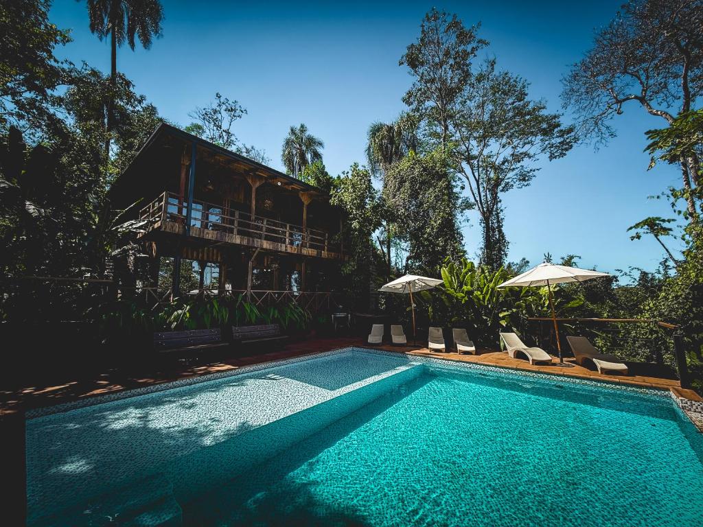 a swimming pool in front of a house at GLAMPING SELVA IGUAZU in Puerto Iguazú