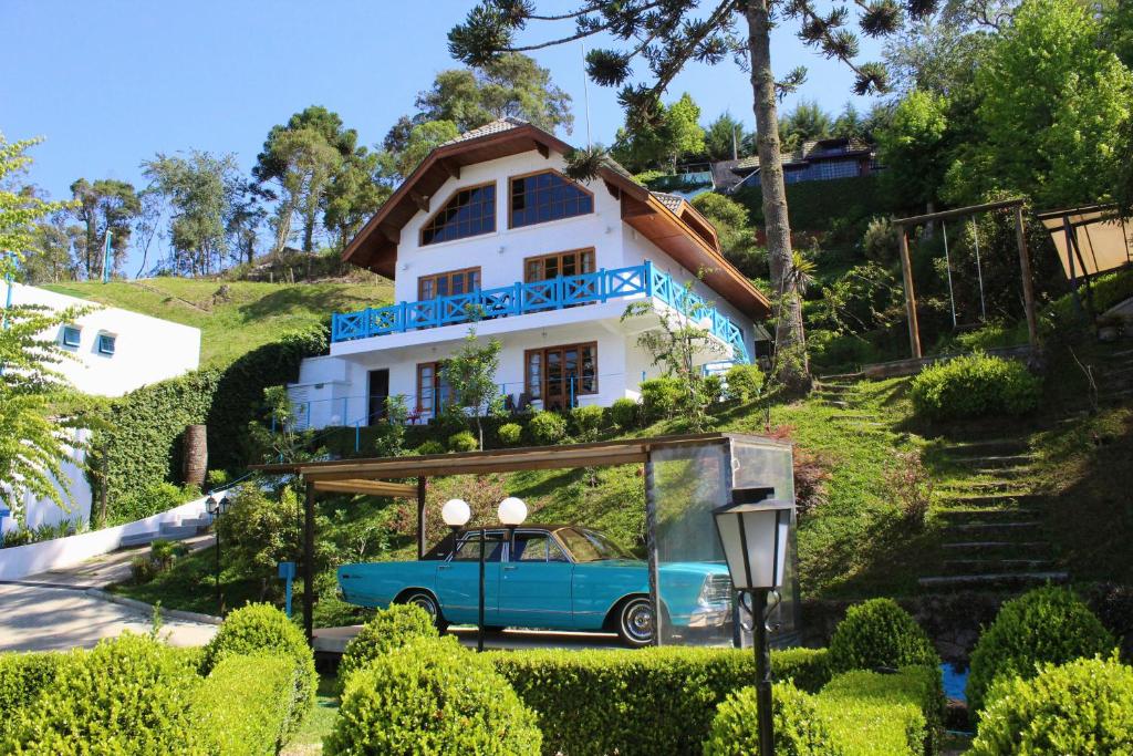 a blue car parked in front of a house at Vila Husky in Campos do Jordão