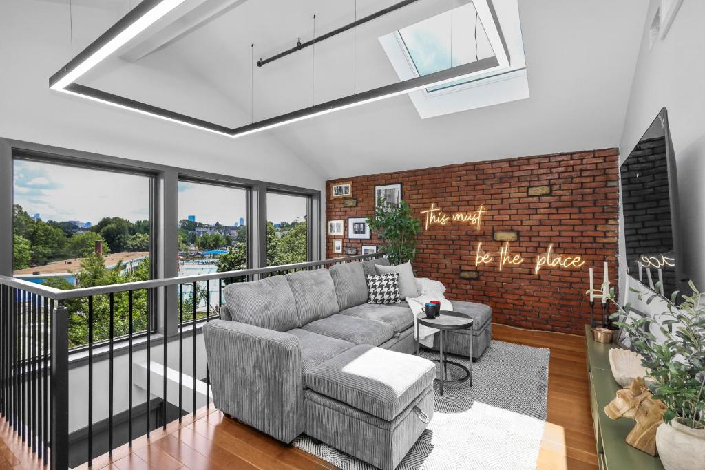 a living room with a couch and a brick wall at Entire House Free Parking Sleeps 26 MIT Harvard TD in Somerville