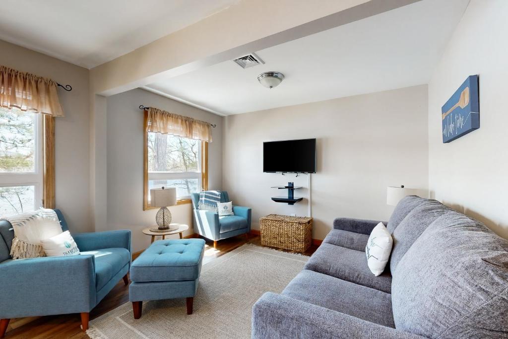 a living room with a couch and chairs and a tv at Bayside Haven in Ossipee