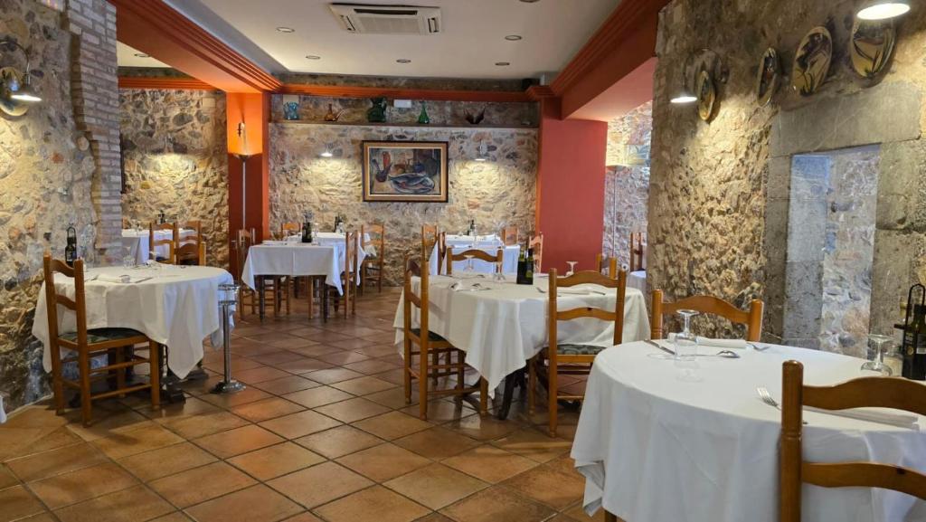 Un restaurante con mesas y sillas con mantel blanco. en Hotel Santa Anna, en L'Estartit