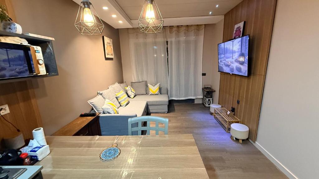 a living room with a couch and a tv at Cosy Appartement Au Centre de Casablanca in Casablanca