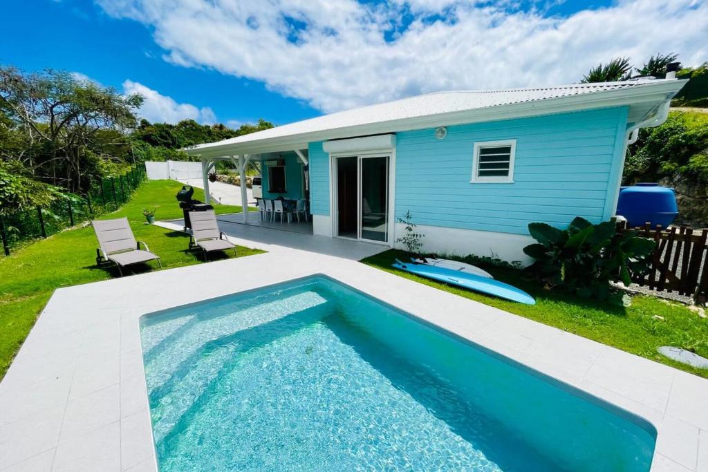 una casa azul con piscina frente a ella en Villa Maeva, en Courcelles Sucrerie