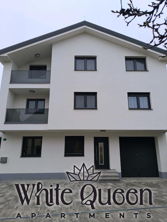 Sanski mostにあるWhite Quenn Apartmentsの白いクイーンアパートメントの建物(目の前に看板あり)