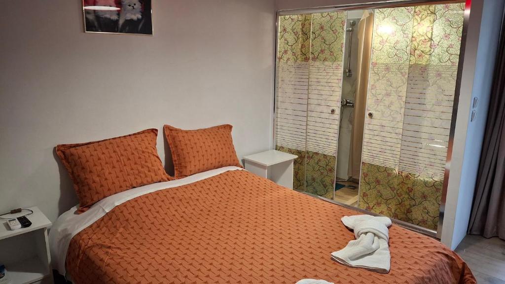 a bedroom with a bed with an orange comforter at Nafpaktos studio in port ΙΙ in Nafpaktos